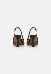Zapatos de tacón alto con estampado de leopardo, tiras negras, espalda descubierta y un tacón grueso. Cuentan con una parte superior de tejido y un forro interior suave.