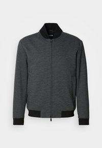 Σκούρο γκρι μπουφάν τύπου bomber με φερμουάρ, ριμπ γιακά και μανσέτες, λεία υφή και πλαϊνές τσέπες. Οριζόντια ραφή στο κάτω μέρος.