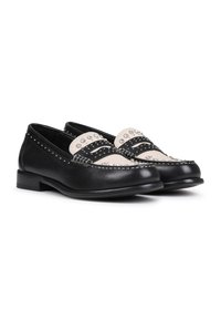 Mocasines de cuero negro con una parte superior de contraste en crema, que presentan acentos con tachuelas y un detalle de costura decorativa en la parte delantera.