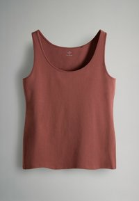 Bezrekawnik w kolorze rdzy, wykonany z gładkiej, miękkiej tkaniny. Posiada szeroki dekolt i prosty dół bez widocznych wzorów ani ozdób.