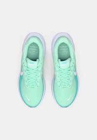 Lichtgroene hardloopschoenen met een bovenwerk van gaas, een gevoerde zool en witte accenten, waaronder een logo. Beschikt over platte veters en een gevoerde kraag.