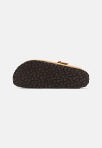 Sandal con zeppa in suede marrone, dotata di una suola in gomma nera testurizzata e di una singola fascia. La parte inferiore presenta un motivo a onde per una maggiore aderenza.