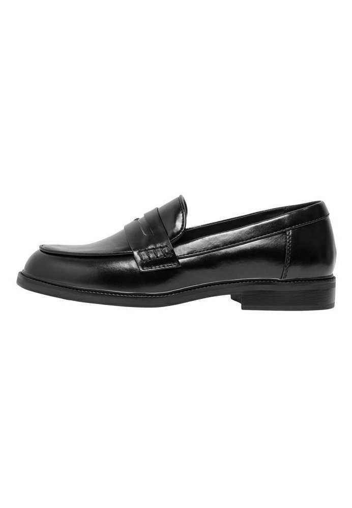 Mocasin de cuero negro con un acabado suave, punta redondeada y costuras decorativas en la parte frontal. Suela de goma plana, diseño clásico.