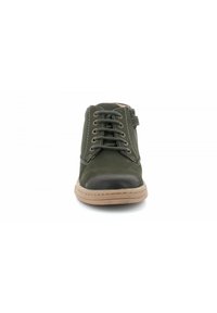 Chaussure vert foncé avec tige en cuir, bout arrondi, capuchon de bout noir contrastant, semelle en caoutchouc marron et fermeture à lacets à six œillets.