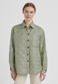 Blassgrüne gesteppte Jacke mit Knopfleiste, Kragen und Brusttasche. Verfügt über ein strukturiertes Muster und geknöpfte Manschetten.