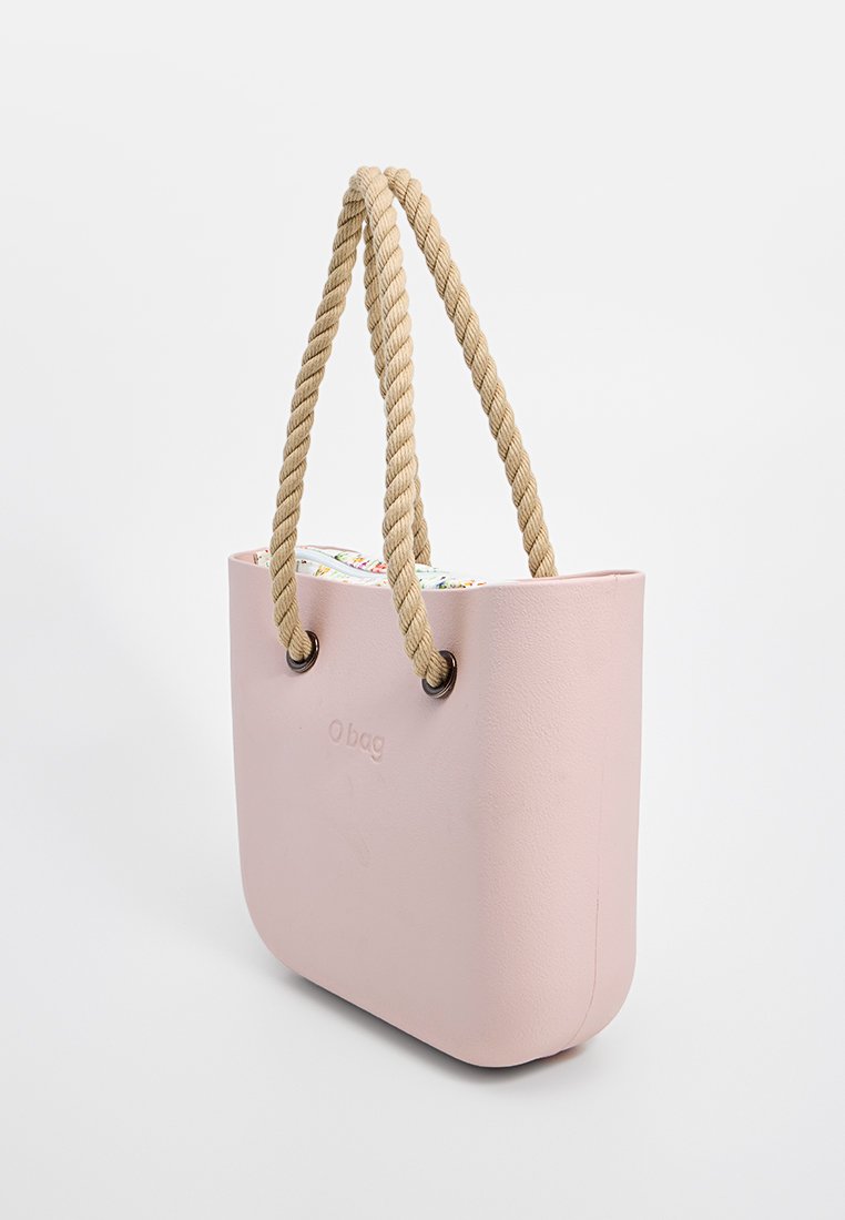 Różowa torba na ramię o gładkim, matowym wykończeniu, z beżowymi sznurkami, zaokrąglonymi krawędziami i wytłoczonym logo po jednej stronie.