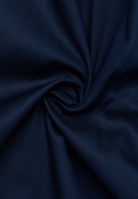 Tessuto blu navy con una superficie liscia e tessuta, caratterizzato da una leggera lucentezza, disposto a spirale per mettere in risalto la sua flessibilità e caduta.