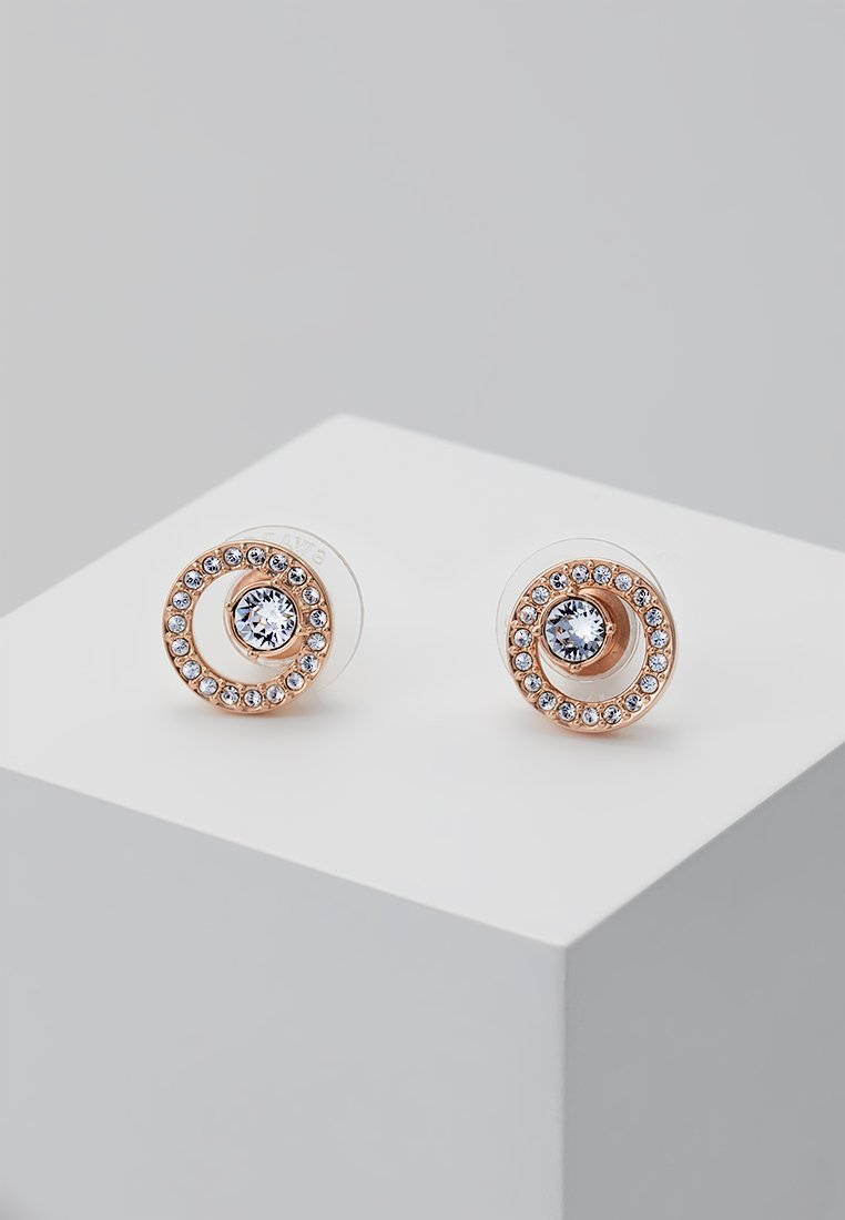 Os brincos de studs circulares em ouro rosa apresentam uma pedra central clara rodeada por pequenas pedras claras, montadas numa base transparente.