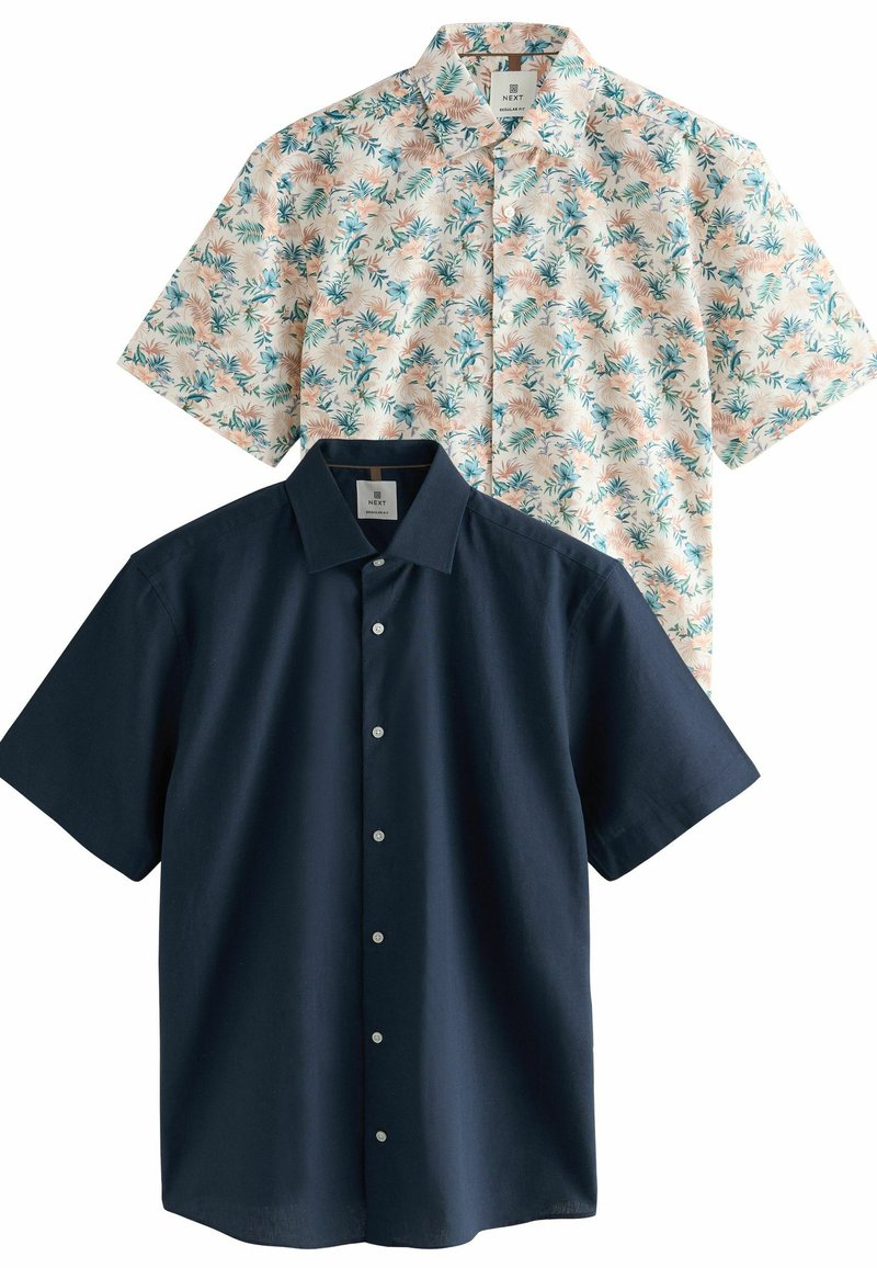 Dos camisas de manga corta: una en azul marino oscuro con botones en el frente, y otra en beige claro con un patrón floral en tonos azules y verdes.
