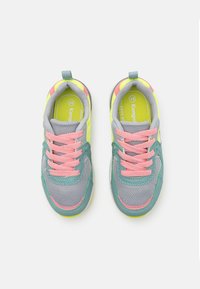 Ett par sneakers för barn med grå mesh, rosa snören, gröna detaljer och neongul innersula, fotograferade ovanifrån på en vit bakgrund.