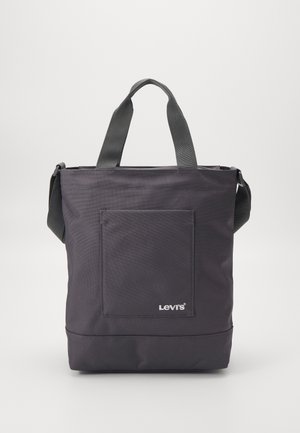 Sort Levi's tote-taske med forlommer, dobbelthåndtag og skulderrem på en ensfarvet baggrund.