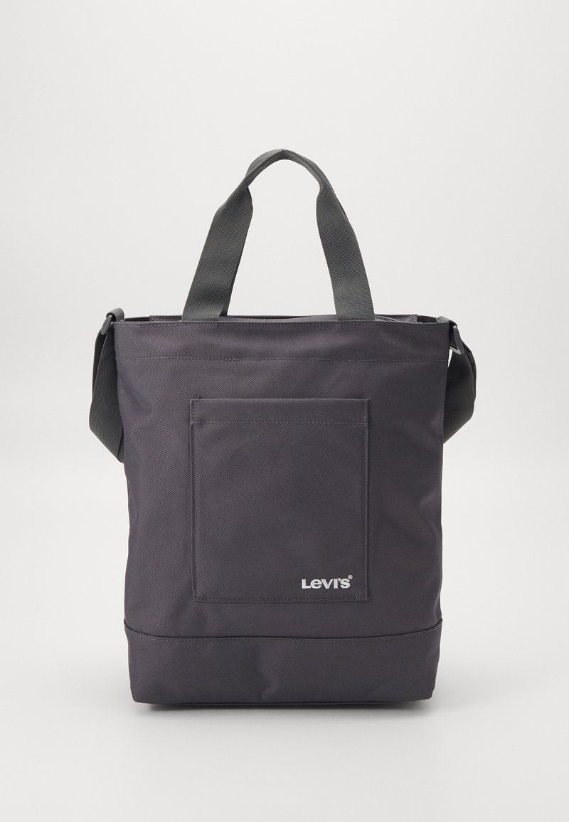 Sac fourre-tout noir Levi's avec poche avant, doubles poignées et une bandoulière sur fond uni.