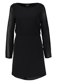 Robe noire avec un col rond et de longues manches en mesh transparent ornées de petits points en relief. Tissu lisse, coupe au genou.