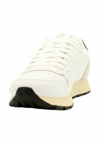 Scarpa da ginnastica bianca con tomaia in pelle liscia, area della punta perforata, dettagli testurizzati e intersuola color crema; suola in gomma nera.