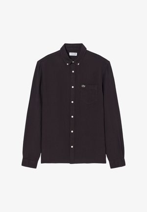 Camisa negra de manga larga con botones y cuello, bolsillo delantero con un pequeño logo de cocodrilo verde.