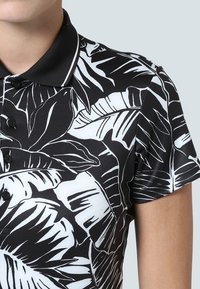 Polo tričko s krátkým rukávem v černé barvě s bílým potiskem listů, s černým límečkem, knoflíkovou légou a hladkým povrchem.