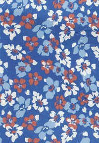 Niebieska tkanina z małymi wzorami kwiatowymi w kolorach czerwonym, jasnoniebieskim i białym, z detalami płatków i liści oraz chropowatą powierzchnią.