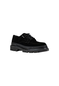 Scarpa nera in suede con lacci, suola in gomma spessa, punta arrotondata e accenti testurizzati. Presenta sei fori per i lacci e un dettaglio di branding minimale.