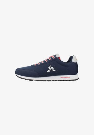 Marineblauwe sportschoenen met witte en rode accenten, synthetisch bovenwerk, ronde neus, opvallend logo op de zijkant en rubberen zool met patroon.