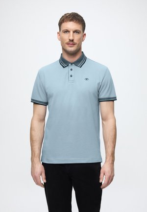 Lichtblauw polohemd met een donkere kraag en accenten op de mouwen, voorzien van drie knopen en een klein logo op de borst.