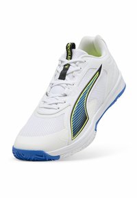 Zapatilla deportiva blanca con logo lateral azul y amarillo, suela azul, cordones blancos y etiqueta negra en la lengüeta con la palabra "ACCELERATE."