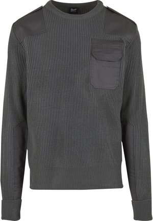 Ciemnoszary dzianinowy sweter z wzmocnionymi łatami na ramionach i łokciach, kieszenią z klapką na lewym biuście oraz ściągaczami na mankietach i dole.