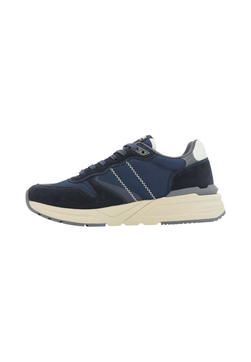 Sneaker blu navy e grigio con strisce zigzag bianche, design con lacci e una soletta spessa beige mostrata di lato.