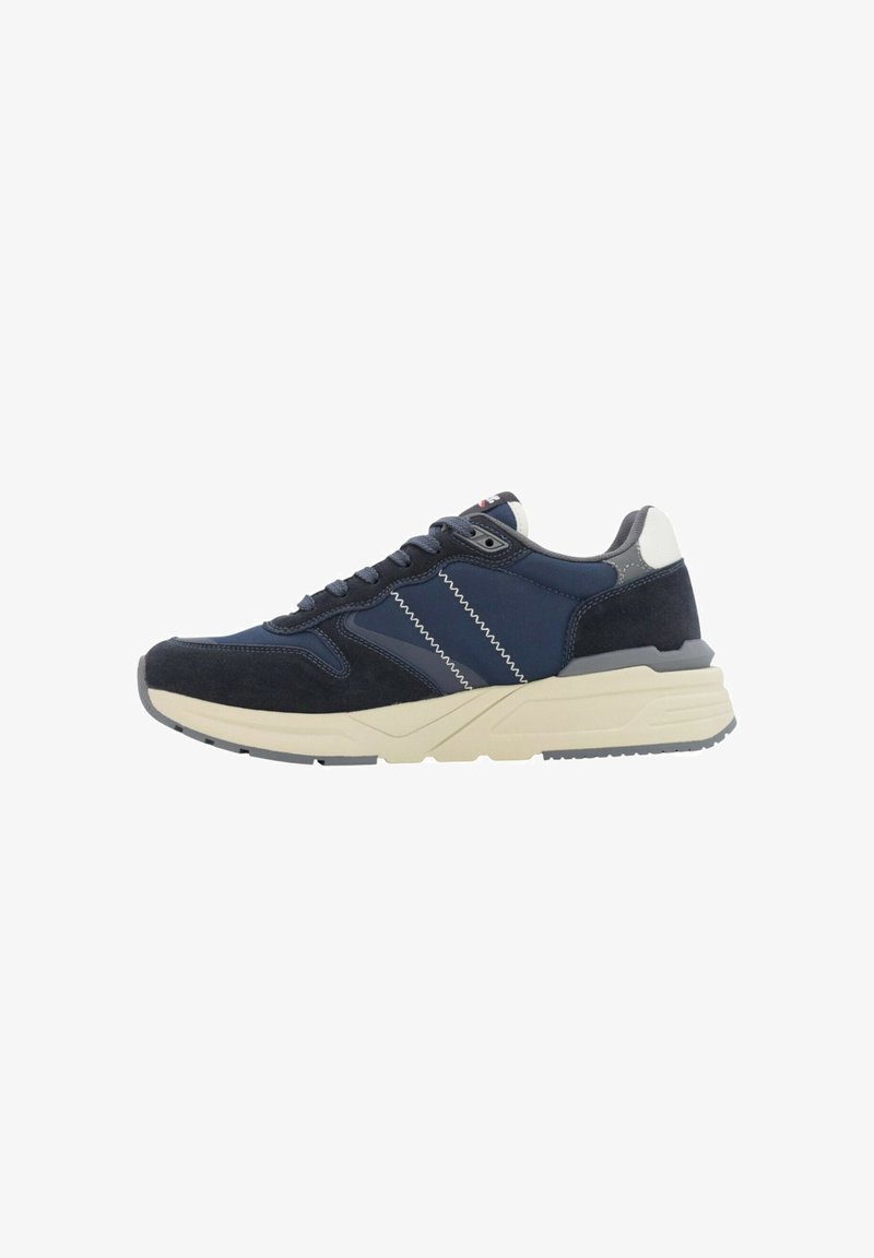 Sneaker blu navy e grigio con strisce zigzag bianche, design con lacci e una soletta spessa beige mostrata di lato.