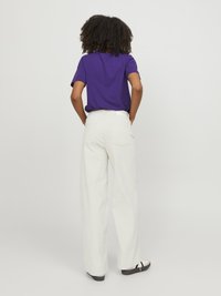 Purple short-sleeve t-shirt paired with high-waisted white wide-leg trousers, featuring a smooth texture and subtle back pocket details.