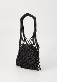 Sac fourre-tout noir tissé avec un design en filet, doté d'une base noire lisse et unie. Les poignées sont délicatement tressées pour une meilleure prise.
