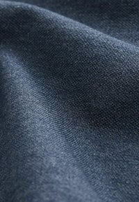 Tejido azul oscuro con una textura suave, que presenta un sutil patrón de punto. El material parece suave y flexible, con un ligero brillo.