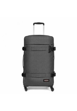 Wheeled suitcase in dark gray fabric, rectangular shape, features a retractable handle, two straps, and a zipper pocket on the front.