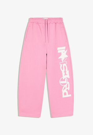 Pantalon de survêtement rose avec taille élastique et cordon, avec un grand texte graphique blanc et un motif étoile le long d'une jambe.