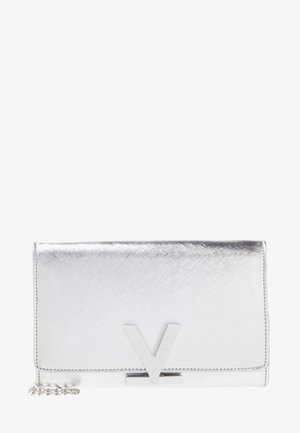 Pochette métallique argentée avec un fermoir en forme de V et une courte chaîne partiellement visible sur le côté gauche.