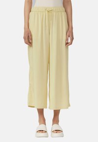 Lichtgele, wijdvallende broek met een elastische tailleband en een trekkoord. Gemaakt van een zachte stof, hebben ze een ontspannen, vloeiende uitstraling.