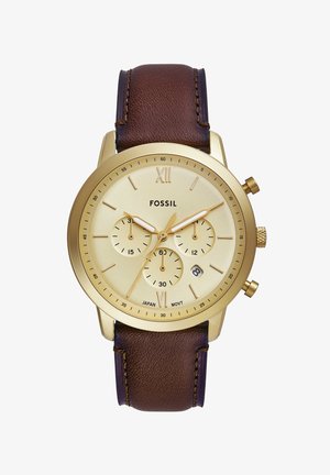 Orologio dorato con tre sottomisure, cinturino in pelle marrone, quadrante crema, numeri romani alle 12 e 6, e cassa in acciaio inossidabile.
