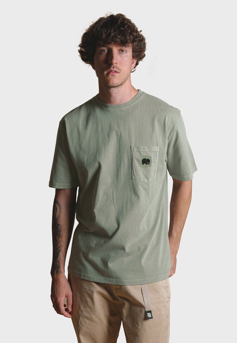 Světle zelené bavlněné tričko s kapsou, s černým logem slona. Krátké rukávy a kulatý výstřih. Hladká textura.