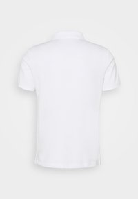 Polo blanc à manches courtes montré de dos avec un col et de petites fentes latérales à l'ourlet.