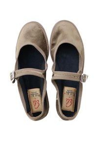 Zapatos planos marrones de ante con diseño de puntera redonda, tira en el tobillo y cierre de hebilla. Forro interior negro y etiquetas de marca visibles.