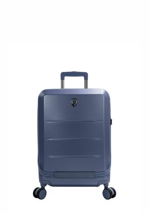 Navy blue hard-shell suitcase with a smooth texture, vertical grooves, telescopic handle, and four swivel wheels for easy mobility.