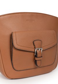 Borsa a mano in pelle color tan con forma strutturata, tasca frontale con chiusura a fibbia argentata e dettagli di cucitura in evidenza.