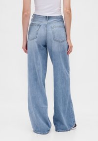 Lichtblauwe wijde jeans van denim. Met een hoge taille en twee achterzakken. Verwerkte textuur met een ontspannen pasvorm.