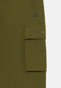 Olivové cargo nohavice s vreckom na patentný gombík. Vyrobené z mäkkej tkaniny, majú na hornej strane logo v tmavšom odtieni.