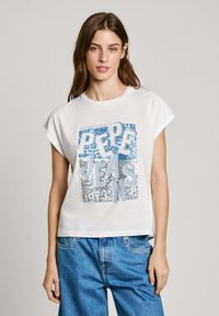 Biela tričko s krátkym rukávom s modro-strieborným dizajnom z flitrov, na ktorom sú v tučných písmenách vytlačené "Pepe Jeans 1973". Vo voľnom strihu.