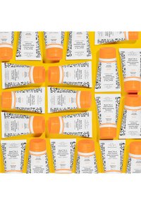 White tubes with black patterns and orange caps, arranged on a yellow background, labeled "Beste No. 9 Jelly Cleanser."