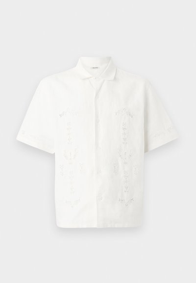 Valge lühikeste varrukatega shirt, mis on valmistatud kerge kangast, sisaldab keerukat lillelist tikandit mitmesugustes mustrites, klassikalise krae ja nööpkinnitusega.