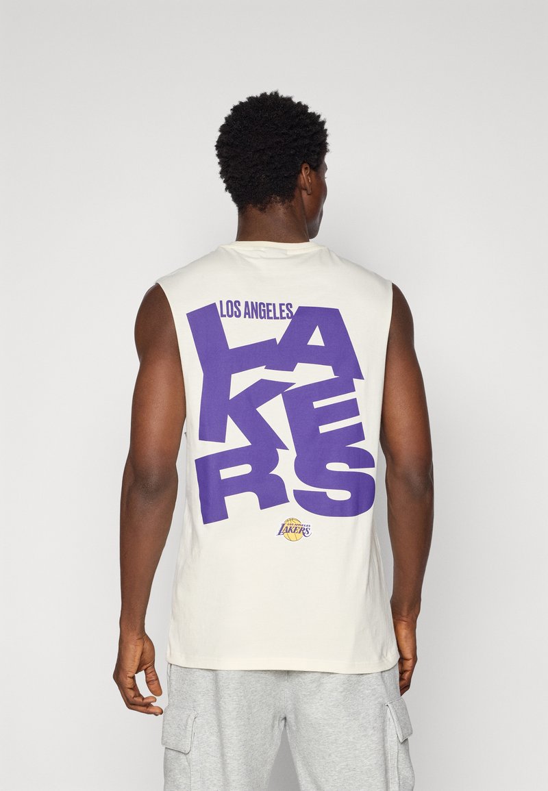 Bezrukávový béžový top s veľkým fialovým textom 'LOS ANGELES LAKERS' na chrbte, s logom na spodnej časti.