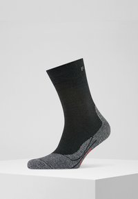 Czarna skarpetka z teksturowanym szarym piętą i palcami, z subtelnym logo na mankiecie i kontrastowym czerwonym akcentem na podeszwie.