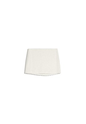 Mini-jupe en dentelle blanche avec ourlet festonné et motif floral subtil, présentée à plat sur fond blanc.