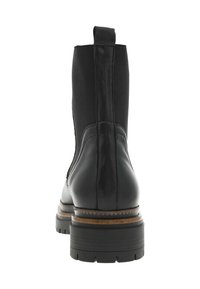 Bottine en cuir noir avec des panneaux latéraux élastiques, finition texturée, semelle en bois empilée et une languette de tirage à l'arrière.